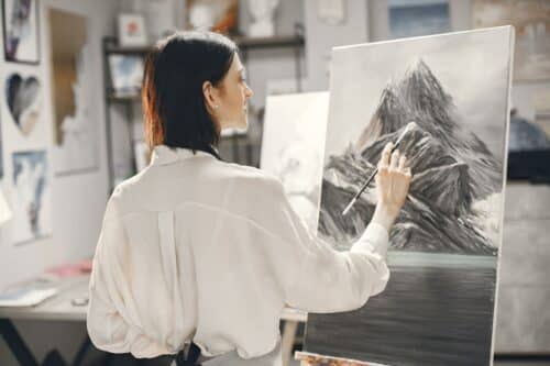 female-artist-paints-picture-on-canvas-with-oil-paints