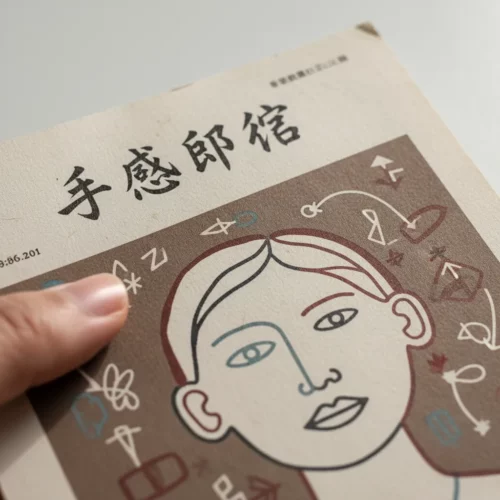 Macro of Lo-Fi print: rough edges, coarse paper, ink bleed. Human finger touches authentic art.